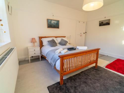 1 dormitorio con 1 cama grande con marco de madera en Pass the Keys Gorgeous 5 bedroom home, en Nottingham