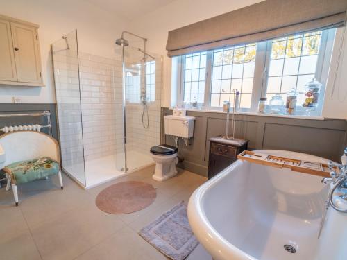y baño con bañera, ducha y aseo. en Pass the Keys Gorgeous 5 bedroom home, en Nottingham