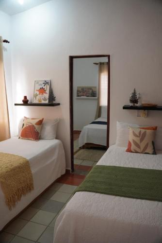 a bedroom with two beds and a mirror at Hotel Montesilva in San Felipe de Puerto Plata