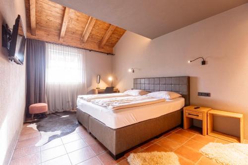 a bedroom with a large bed and a window at Tauernsuites Mitterwirt by ALPS RESORTS in Piesendorf