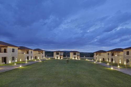 a large yard with lights in front of buildings at ELEVRES STONE HOUSE HOTEL in Urgup