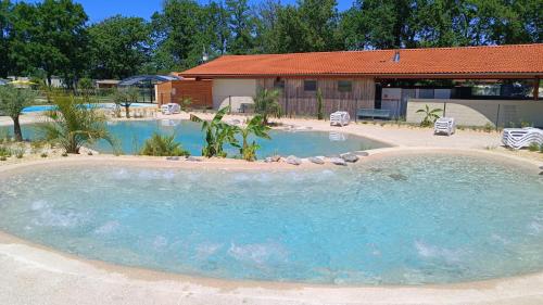 a large swimming pool in the middle of a yard at Mobil Home XXL 4 chambres - Camping du Vieux Moulin in Vensac