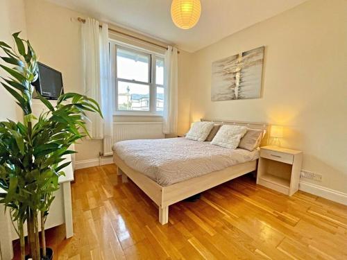 a bedroom with a bed and a potted plant at Kanangra, 2 bedroom apartment in Teignmouth in Teignmouth