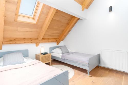 2 Betten in einem Zimmer mit Holzdecken in der Unterkunft Maisonette Apartment in Karlín by Prague Days in Prag