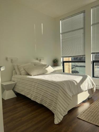 a white bed in a bedroom with a window at Laid Back In Langford in Langford