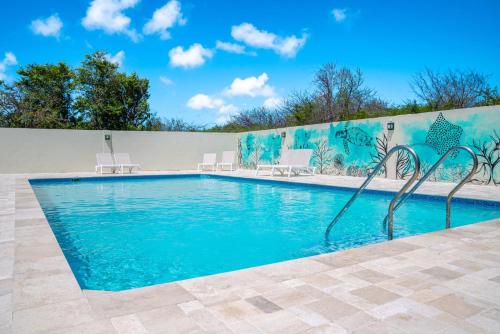een zwembad met blauw water voor een muur bij Dream of the Green Flamingo in Willibrordus
