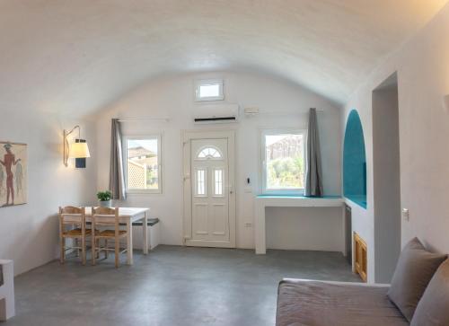 a living room with a table and a white door at Villas Scirocco in Fira