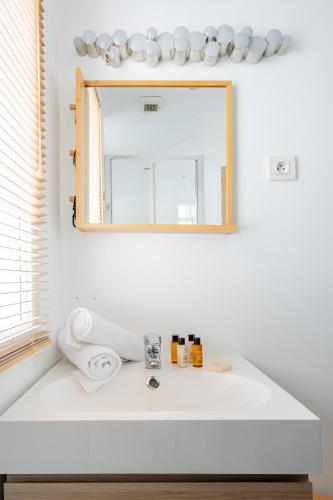 une salle de bain avec un lavabo blanc et un miroir dans l'établissement Veeve - Batignolles Blues, à Paris