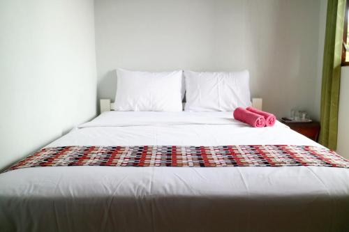 a bed with a red towel on top of it at The Homey Rooms and Tours in Yogyakarta