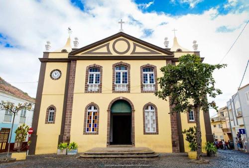 Una iglesia con un reloj en la parte delantera. en Bela Sombra en Vila da Ribeira Brava