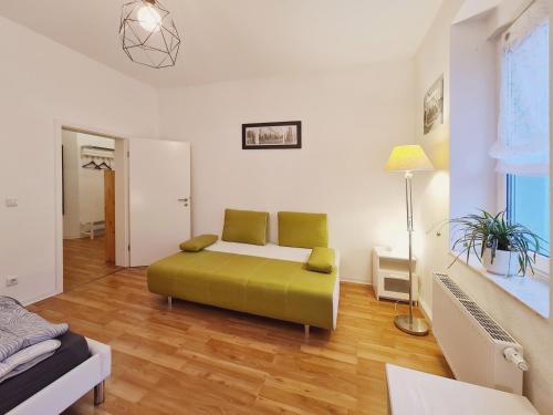 愛爾福特的住宿－Suite am Park，一间位于客房内的带绿色沙发的卧室
