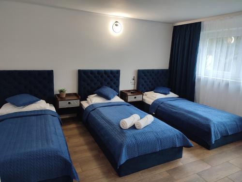 a hotel room with two beds with blue sheets at Apartament LoftyDream in Mielec