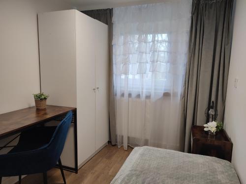 a bedroom with a bed and a desk and a window at Apartament LoftyDream in Mielec