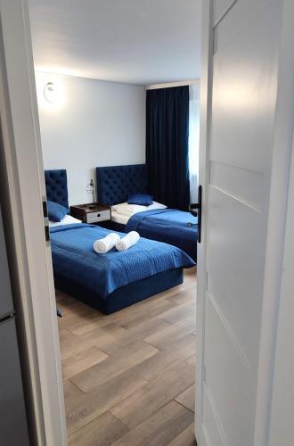 a bedroom with two beds and a door open at Apartament LoftyDream in Mielec