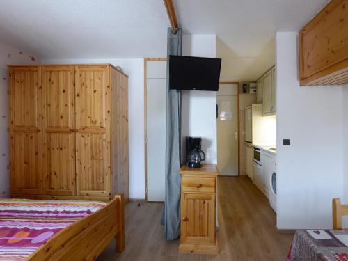 - une chambre avec un lit et une télévision dans l'établissement Studio fonctionnel au centre station avec balcon et vue montagne, 2 étoiles - FR-1-181-2494, à La Plagne Tarentaise