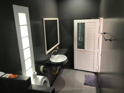 łazienka z białą umywalką i drzwiami w obiekcie ภูรักษ์รีสอร์ท บ้านกรูด 