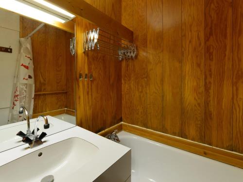 La salle de bains est pourvue d'un lavabo blanc et de murs en bois. dans l'établissement Studio confortable au cœur de Montchavin avec casier à skis et accès télécabine - FR-1-181-2551, à La Plagne Tarentaise