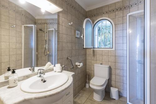 een badkamer met een wastafel, een toilet en een douche bij Casa Alba in Jávea