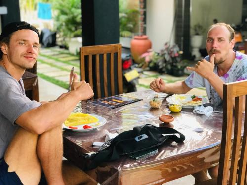 two men sitting at a table eating food at Hiriketiya New Radiant House in Dickwella