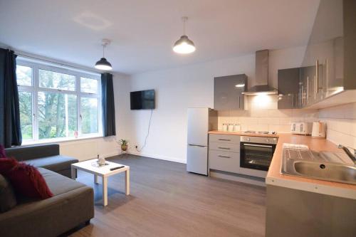a kitchen and living room with a couch and a table at Contemporary 3 Bedroom Flat in Fife