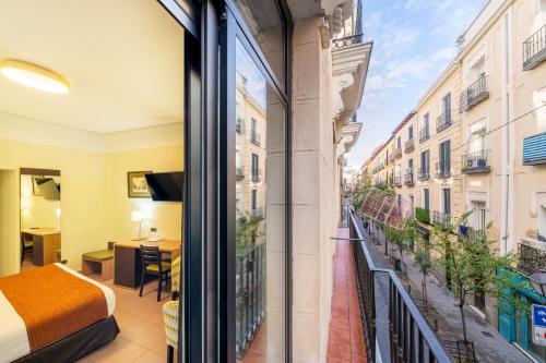 Cette chambre offre une vue sur un balcon doté d'un lit. dans l'établissement Hostal Ballesta, à Madrid