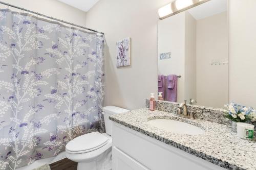 a bathroom with a toilet and a shower curtain at Vineyards Escape 3 in Branson