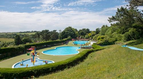 - un parc aquatique avec 2 piscines dans un champ dans l'établissement Luxury 3 bedroom Maple View Lodge, Newquay, Cornwall, à Newquay
