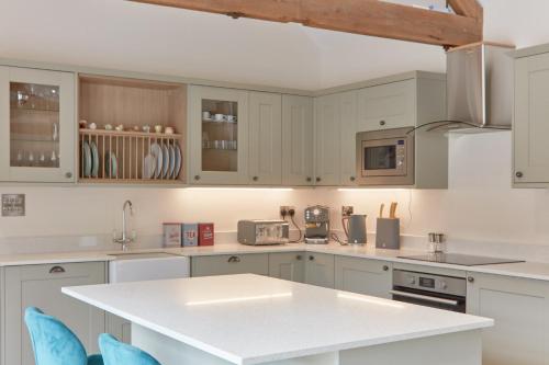 a kitchen with white cabinets and a white counter top at Hayes Farm - 8 Houses in Gloucester