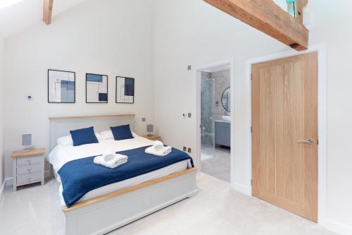 a white bedroom with a bed and a bathroom at Hayes Farm - 8 Houses in Gloucester