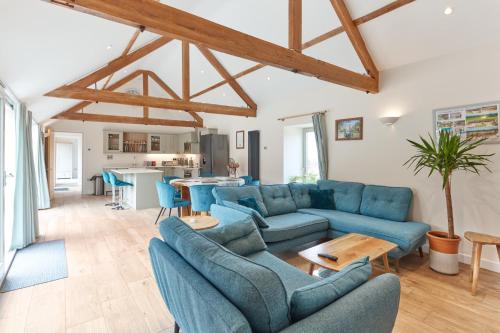 a living room with blue couches and a table at Hayes Farm - 8 Houses in Gloucester