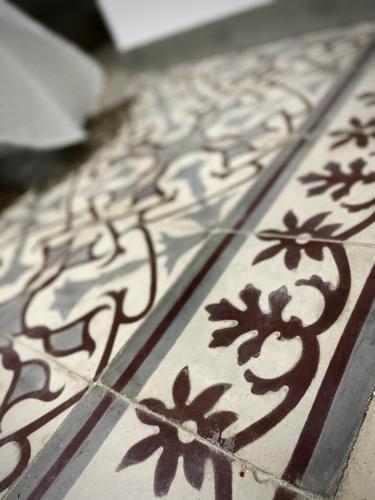 a close up of a tile floor with drawings on it at Alojamientos El Carmen in Écija