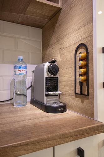 a coffee maker on a counter with a bottle of water at Sunny Nest Apartment in Fontana