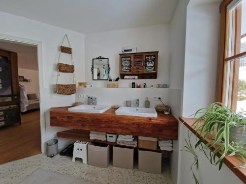 uma casa de banho com 2 lavatórios e um balcão de madeira em Exclusive 120 qm Wohnung am Wössner em Unterwössen