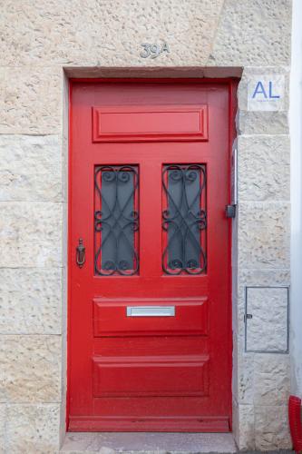 a red door with a window in a building at Casas da Couraça in Coimbra