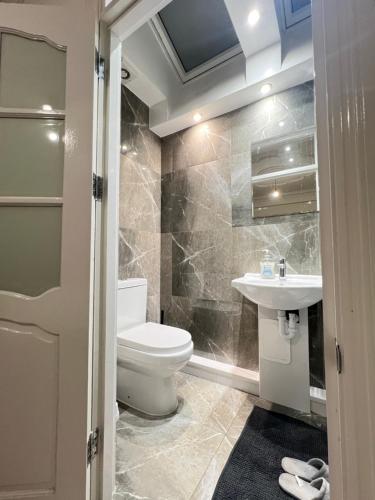 a bathroom with a toilet and a sink at StayEasy En-Suite London in London