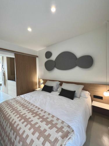 1 dormitorio con 1 cama blanca grande con almohadas negras en Casabell 3 Caminito del Rey, en Valle de Abdalajís