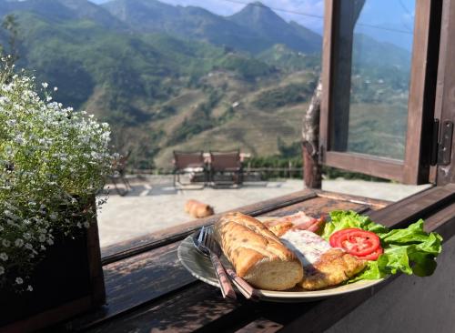 a plate of food with bread and vegetables on a balcony at Pavi garden in Sa Pa