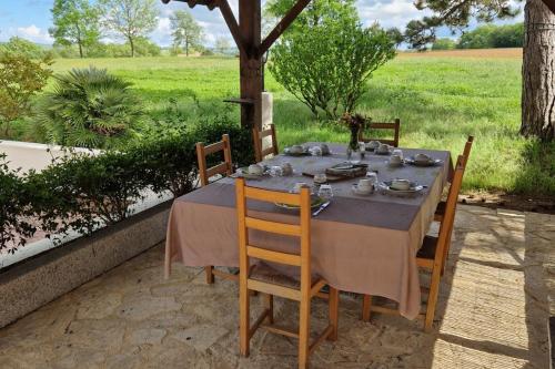 Chambre Aramis في Ayguetinte: طاولة طعام عليها كراسي ومفرش