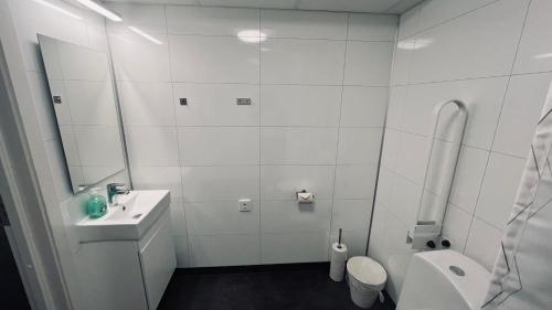 a white bathroom with a sink and a toilet at Rentalux Apartments at Vivansborg in Timrå