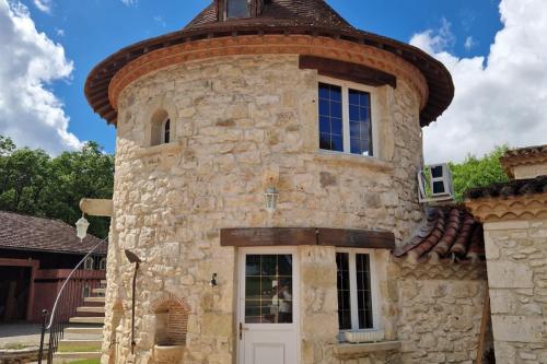 un gran edificio de piedra con una parte superior redonda en La Tour de Pérès, en Ayguetinte