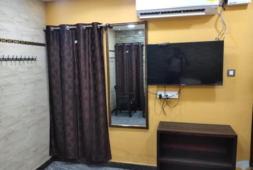 a mirror and a television on a wall at MERCY INN in Chennai