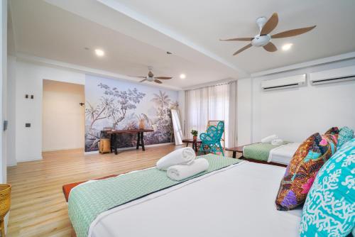 a bedroom with two beds and a ceiling fan at Villapadu Bayu in Kuala Terengganu