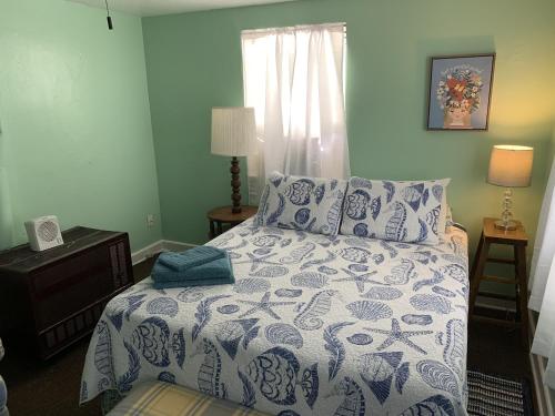 ein Schlafzimmer mit einem Bett mit einer blau-weißen Bettdecke in der Unterkunft Beach Side Studio #1 apts in North Camellia Acres