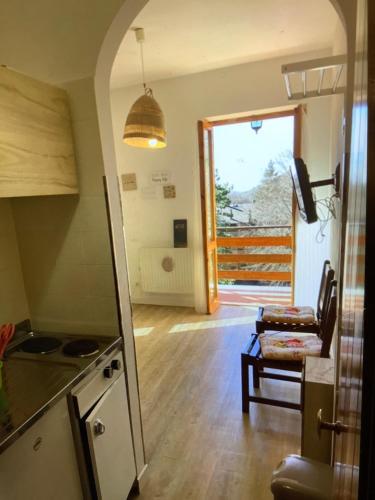 a kitchen and living room with a door to a balcony at A casa di Giulia in Filettino