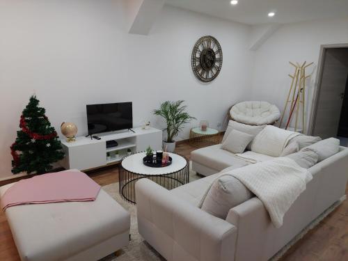 Elle comprend un salon doté d'un mobilier blanc et d'un arbre de Noël. dans l'établissement Le Bag Centre ville, à Colmar