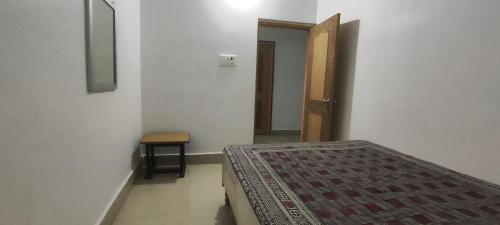 a bedroom with a bed and a door and a table at Anand Inn in Bodh Gaya
