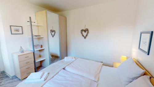 ein Schlafzimmer mit einem Bett und eine Kommode mit einem Spiegel in der Unterkunft Sonnenhügel App. 04 in Grömitz