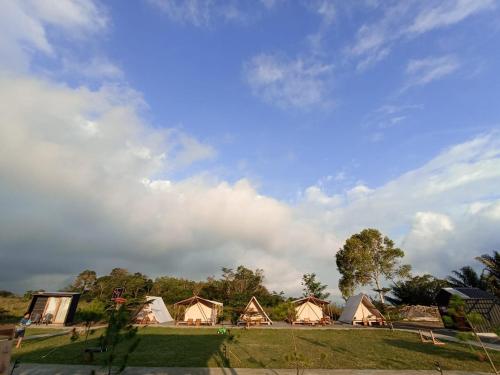 a group of tents in a field under a cloudy sky at Wawowow in Tomohon