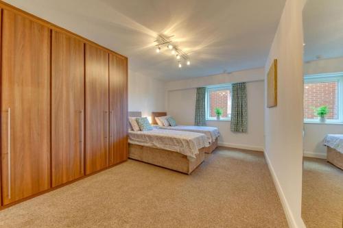 een slaapkamer met een bed en een grote houten kast bij Stunning Central Space in the City 2BR 2BA in Sheffield