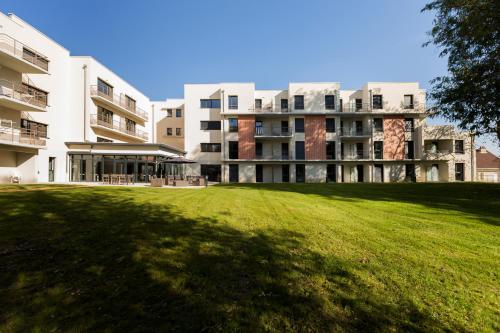 a large grassy field in front of a building at Zenao Appart'Hotel in Nevers